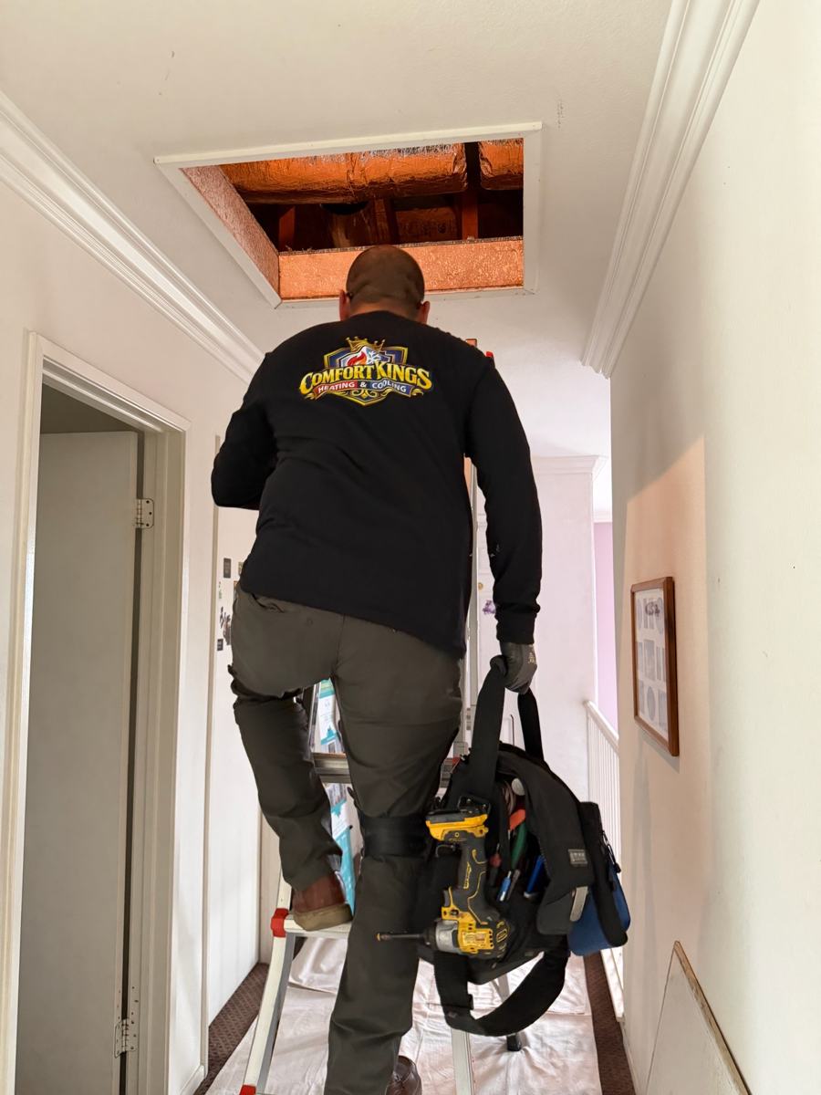 Técnico subiendo al ático para un mantenimiento de calefacción